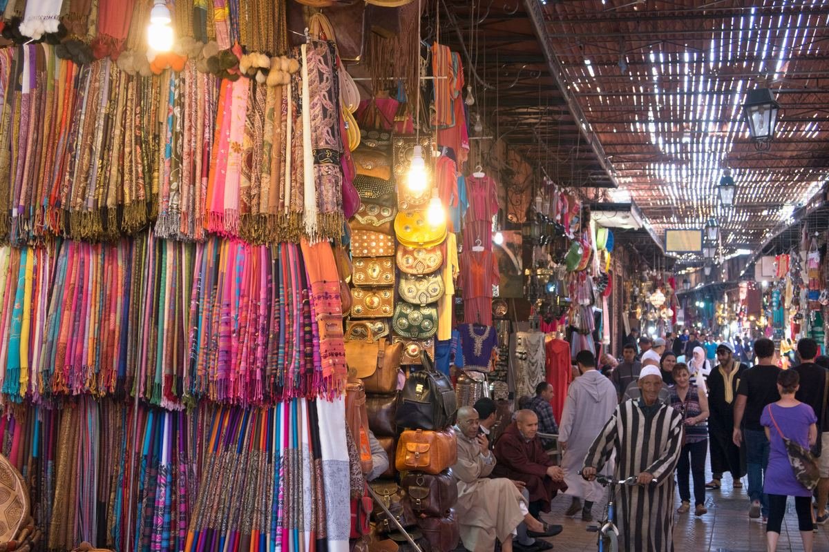 Crowded covered souk lined with colourful textiles